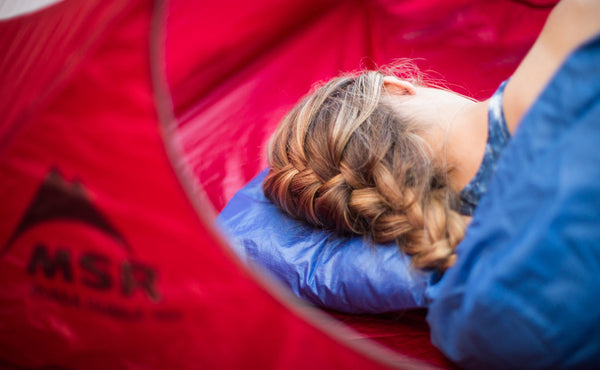 A person using the Pocket Travel Pillow in a tent.